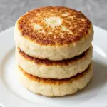 Crispy potato pancakes served on a plate with sour cream and herbs